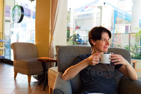 HUA HIN, THAILAND - SEPTEMBER 7, 2015: Happy tourist relaxes in the Starbucks coffee shop in Hua Hin.のeditorial素材