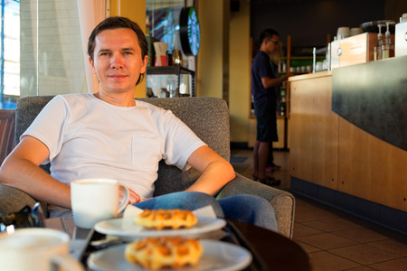 HUA HIN, THAILAND - SEPTEMBER 7, 2015: Happy tourist relaxes in the Starbucks coffee shop in Hua Hin.のeditorial素材