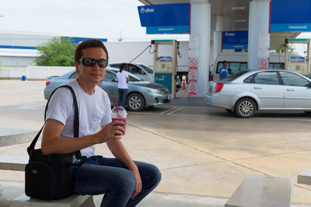 HUA HIN, THAILAND - SEPTEMBER 8, 2015: Tourist awaits the tour bus on the gas station.のeditorial素材