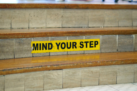 Stairs with"Mind your step" safety caution sign about slips, trips and falls hazard.
の写真素材