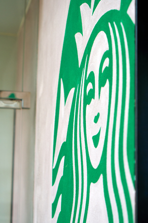 HONG KONG - September 2, 2017: Fragment of Starbucks coffeehouse chain signage painted on a stucco wall. Illustrative editorial.のeditorial素材