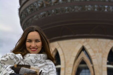 Beautiful girl in a vintage striped scarf on the streetの写真素材