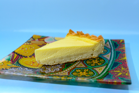 piece of delicate sour cheesecake on a colored plateの写真素材