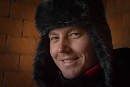 Portret of smile young guy with fur hat