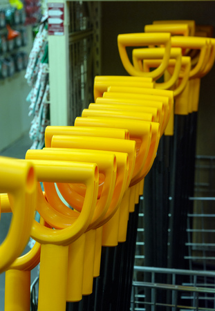 Orange handles of the shovels in the storeの写真素材