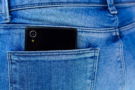 closeup of Black smartphone in back pocket of girl's jeansの写真素材