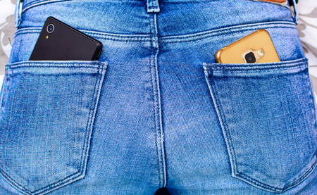 closeup of Black and Gold smartphone in back pocket of girl's jeansの写真素材