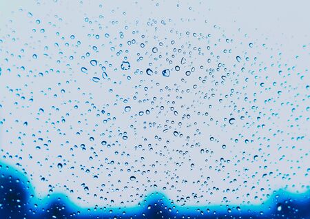 rain drops on car glass, tinted aquamarineの写真素材