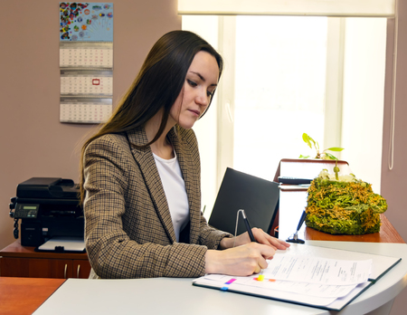 Business Woman at office desk signing a contract