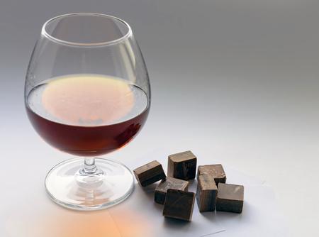 glass of brandy and dark chocolate piecesの写真素材