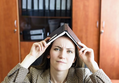 Beautiful tired business woman, massaging the bridge of his nose while working in the office. Headaches from workingの写真素材
