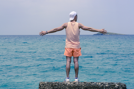 Enjoying life. Young man looking at the sea, vacations lifestyle concept.