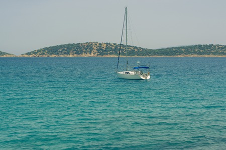 Beautiful seascape with white sailing yacht in the blue sea. Lowered the sails, calm. The concept of stagnation, no purpose, dropped his handsの写真素材
