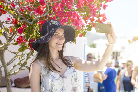 young smiling woman in hat taking a selfie on vacationの写真素材