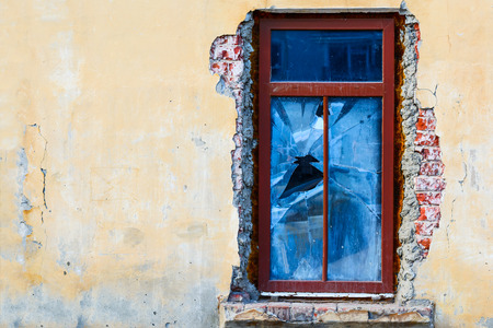 Old crush window on an abandoned old building. broken window on the yellow wall. Old and dirty wall of the interior of old buildings.の写真素材