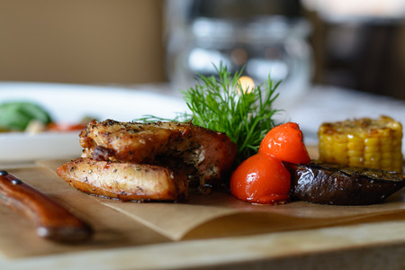 turkey with corn, eggplant, Bulgarian pepper, greens grilled on wooden plate, top viewの写真素材