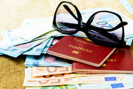 Passports with european union currency and sunglasses on a map background. Travel conceptの写真素材