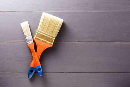 Pair of gloves with a brush on grey wooden background with copy space. Flat lay. Top viewの写真素材