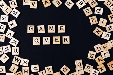 Word BOARD GAME with wooden letters on black board and letter in the circle.の写真素材