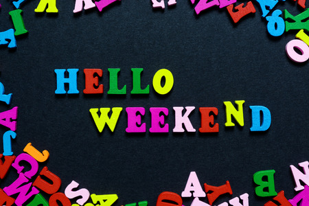 concept design - the word HELLO WEEKEND from multi-colored wooden letters on a black background, creative idea.の写真素材