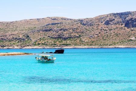 Small white fishing boat anchored in the azure Harborの写真素材