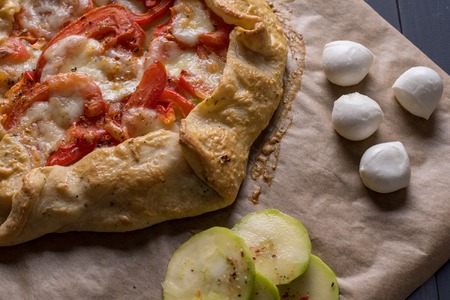 Home Gallet with tomatoes mozzarella cheese and zucchini on a wooden tableの写真素材