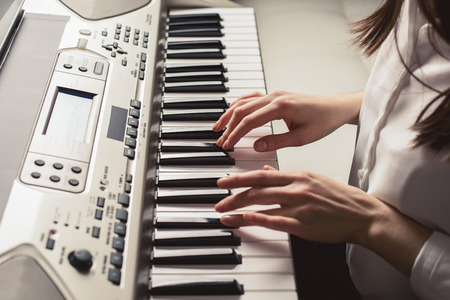 Side view of female hands on practice play on the sequencer.の写真素材