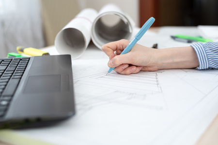 The concept of creating an architectural plan, hands with a pencil and laptop.の写真素材