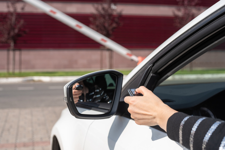 system of remote opening of a gate, female hand with the panel opens a barrier from the car