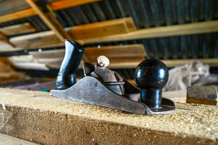 Vintage hand planer on the Board with sawdust in the carpenter shop.