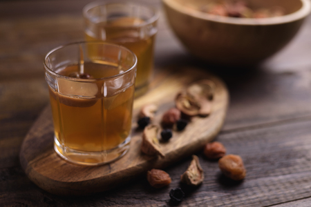 close-up of dried fruit compote in glass cups and assorted in a wooden bowl on a wooden board....