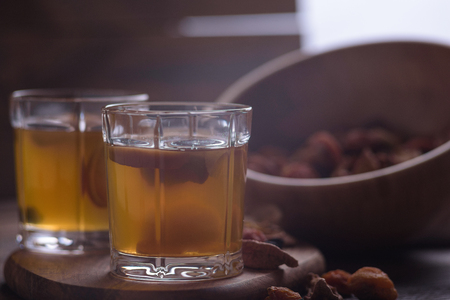 close-up of compote in glasses with a wooden bowl filled with assorted dried fruits. Selective focusの写真素材