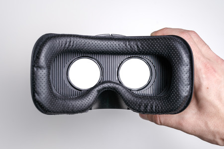 close-up of virtual reality glasses in a man hand on a white background, layout