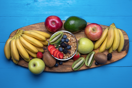 Top view of bright assorted fruits, bananas, apples, mangoes, kiwi, strawberries, blueberries, with cereals for a healthy Breakfast.の写真素材