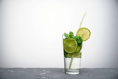 refreshing summer cocktail with lemon, lime and mint on light grey background with copy spaceの写真素材