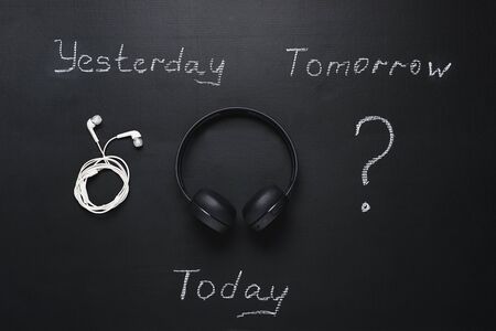 evolution of gadgets for music. wired headphones, wireless headphones and question mark for the...