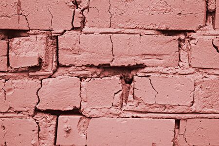 Macro image of an old cracked brick wall toned in the color of living coral, creative mock up