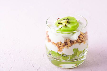 close up of dessert with kiwi, granola and cottage cheese on pink background with copy spaceの写真素材