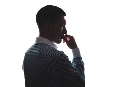 silhouette of Caucasian man on the side in business shirt hand at mouth, thinking kind of pose Homerの写真素材