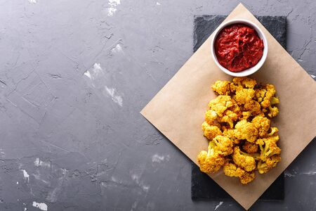 roasted cauliflower with tomato sauce on grey background.の写真素材