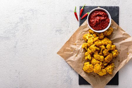 cauliflower with tomato sauce on Kraft paper on white background with copy space. garnish conceptの写真素材