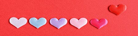 small multicolored hearts in row on red background for banner for Valentine's dayの写真素材
