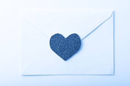 love e-mail letter in white envelope with heart on tinted in color of the year-classic blue background for Valentine's dayの写真素材