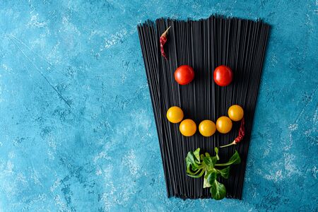 ingredients for Italian dinner, black spaghetti with cuttlefish ink, tomatoes, lettuce, chili...