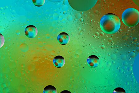 iridescent bubbles on colored green background, art texture concept