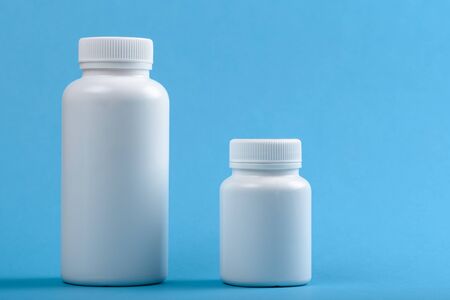 two white plastic bottles on blue background for brand and text