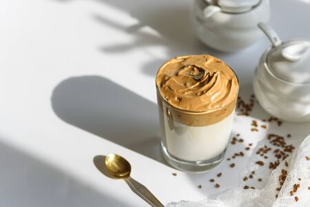 top view trendy dalgona coffee in glass with shadow on white background, iced coffee, whipped coffee, korean coffee conceptの写真素材