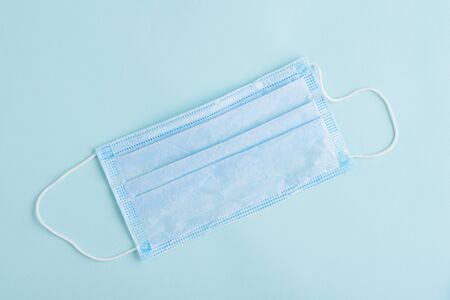 top view one disposable medical mask on blue background