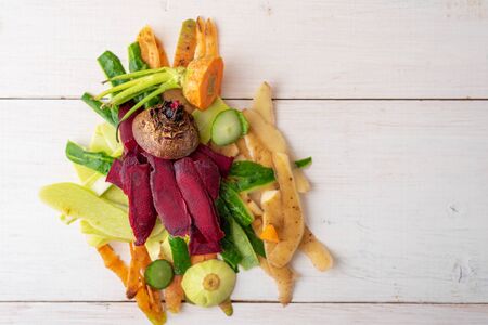 recycling of food waste, vegetable cleaning, peels on white wooden background, compost concept, top...
