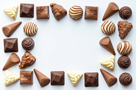 chocolate candies frame on white background, copy space, top view, space for text, world chocolate day conceptの写真素材